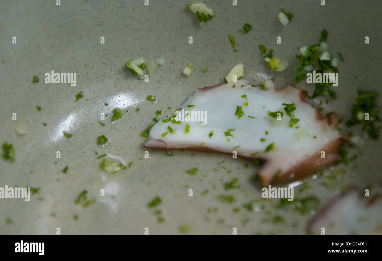 Tintenfisch mit gehackter Petersilie in einer Schüssel in dünne Scheiben geschnitten Stockfoto