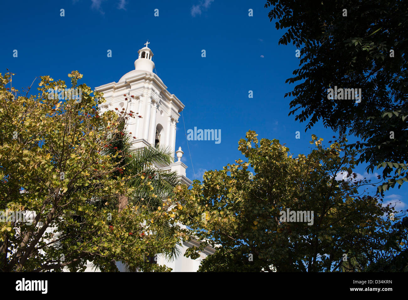 Der Turm erhebt sich Abopve die Bäume der Iglesia El Calvario Kirche in Chinandega, Nicaragua Stockfoto