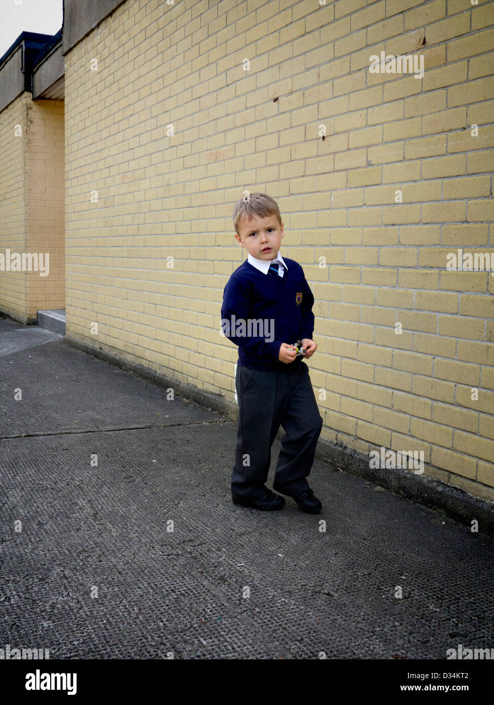 Ein kleiner Junge in Hof gekleidet in seiner Schuluniform Stockfoto