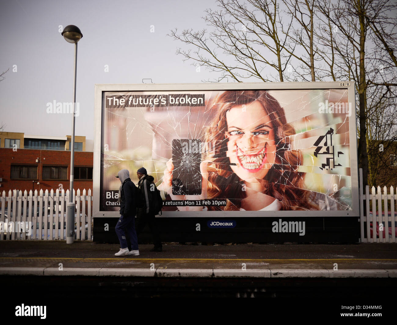 Großbritannien gebrochen, Anzeige der Futures gebrochen Channel 4 TV auf Horten mit zwei Jugendlichen, die zu Fuß vorbei am Bahnhof London Stockfoto