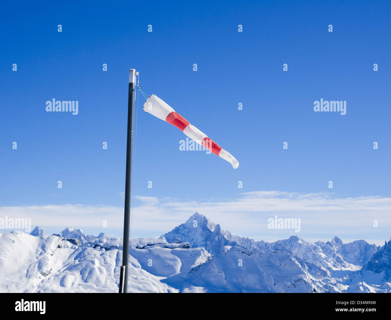 Windsack an einem windigen Tag im Les Grandes Platieres in Le Grand Massif mit Blick auf schneebedeckte Berge in Französische Alpen Frankreich Stockfoto
