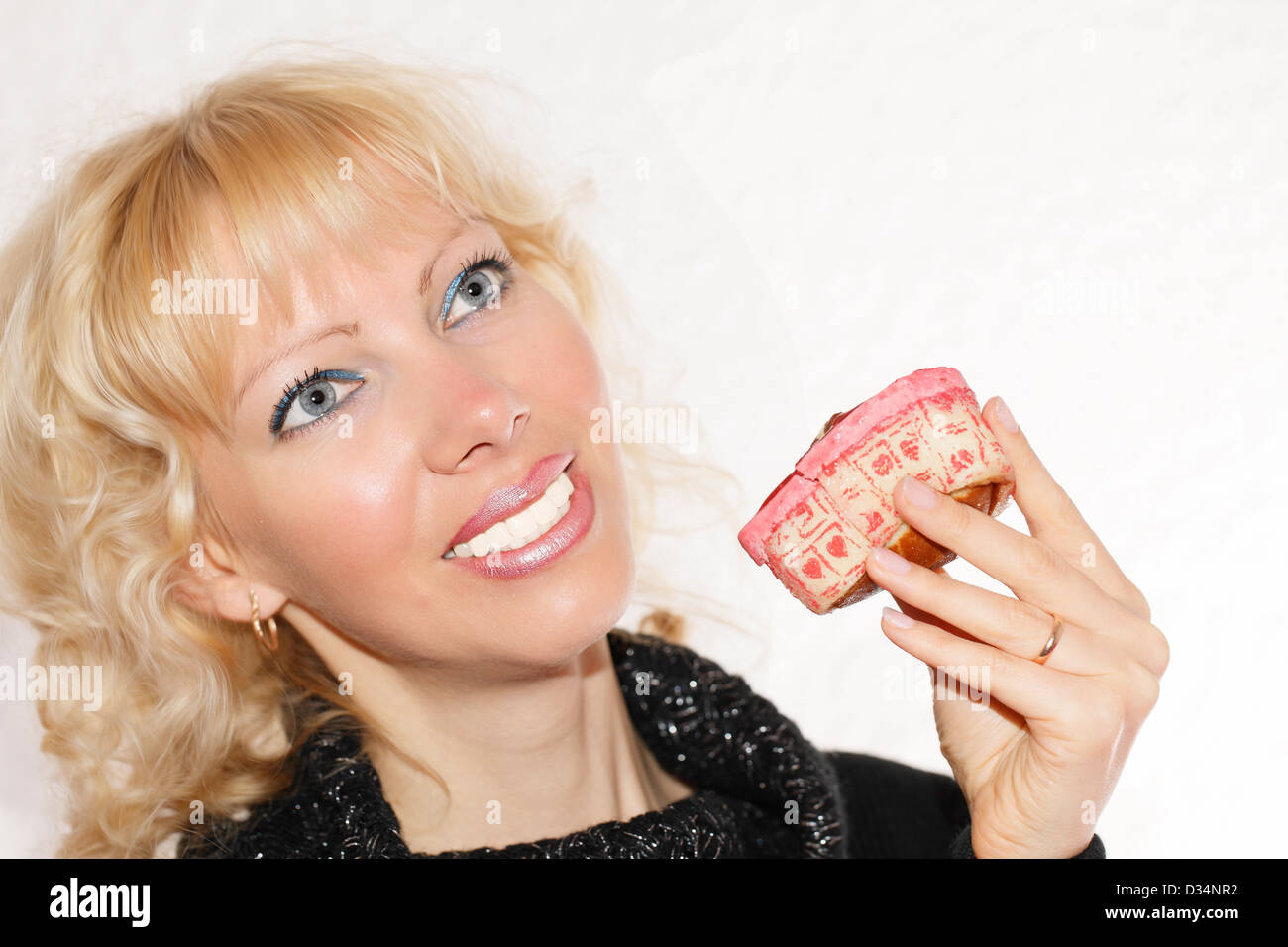 Junge, blonde Frau mit einem Valentin-Kuchen Stockfoto