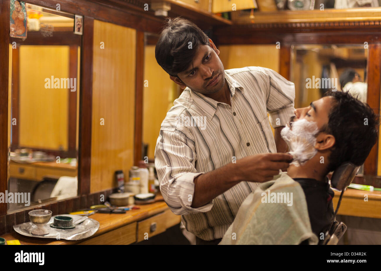 Barbier rasieren ein Kunde, Varanasi, Indien Stockfoto