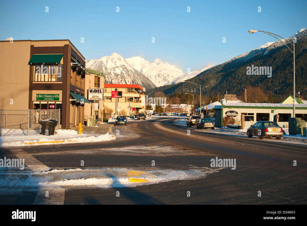 Malerische Aussicht auf die schneebedeckten Berge und die Innenstadt von Sitka, Alaska auf einem klaren, kalten Wintertag. Stockfoto