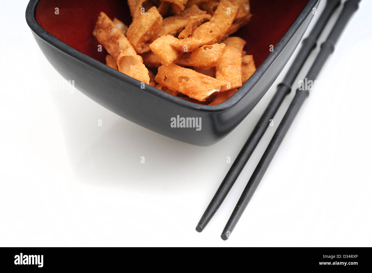 Gebratene Wan-Tan-Streifen oder chinesisches Essen in Schüssel mit Stäbchen Stockfoto