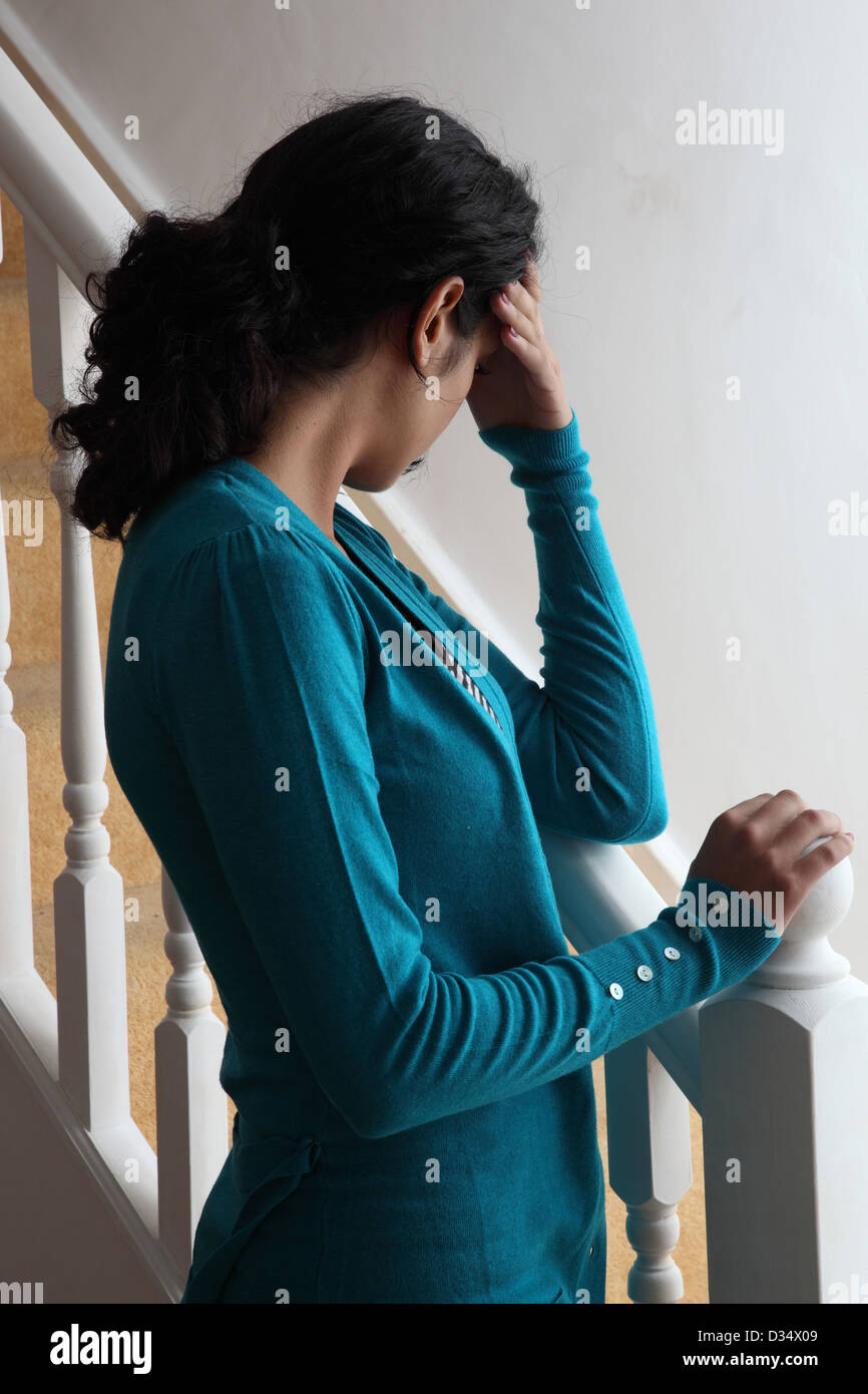 Eine junge Frau, die allein auf den Stufen, dunkle Silhouette. Stockfoto