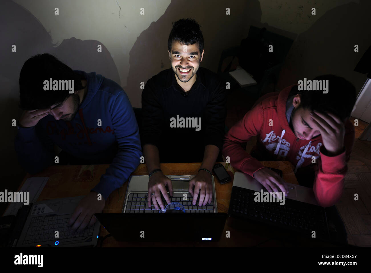 Drei junge Männer, die mit Laptops Stockfoto