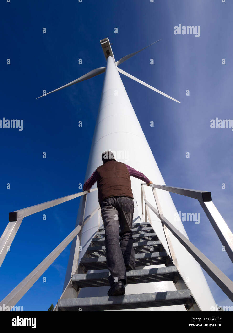 Mann neben Windkraftanlage Stockfoto