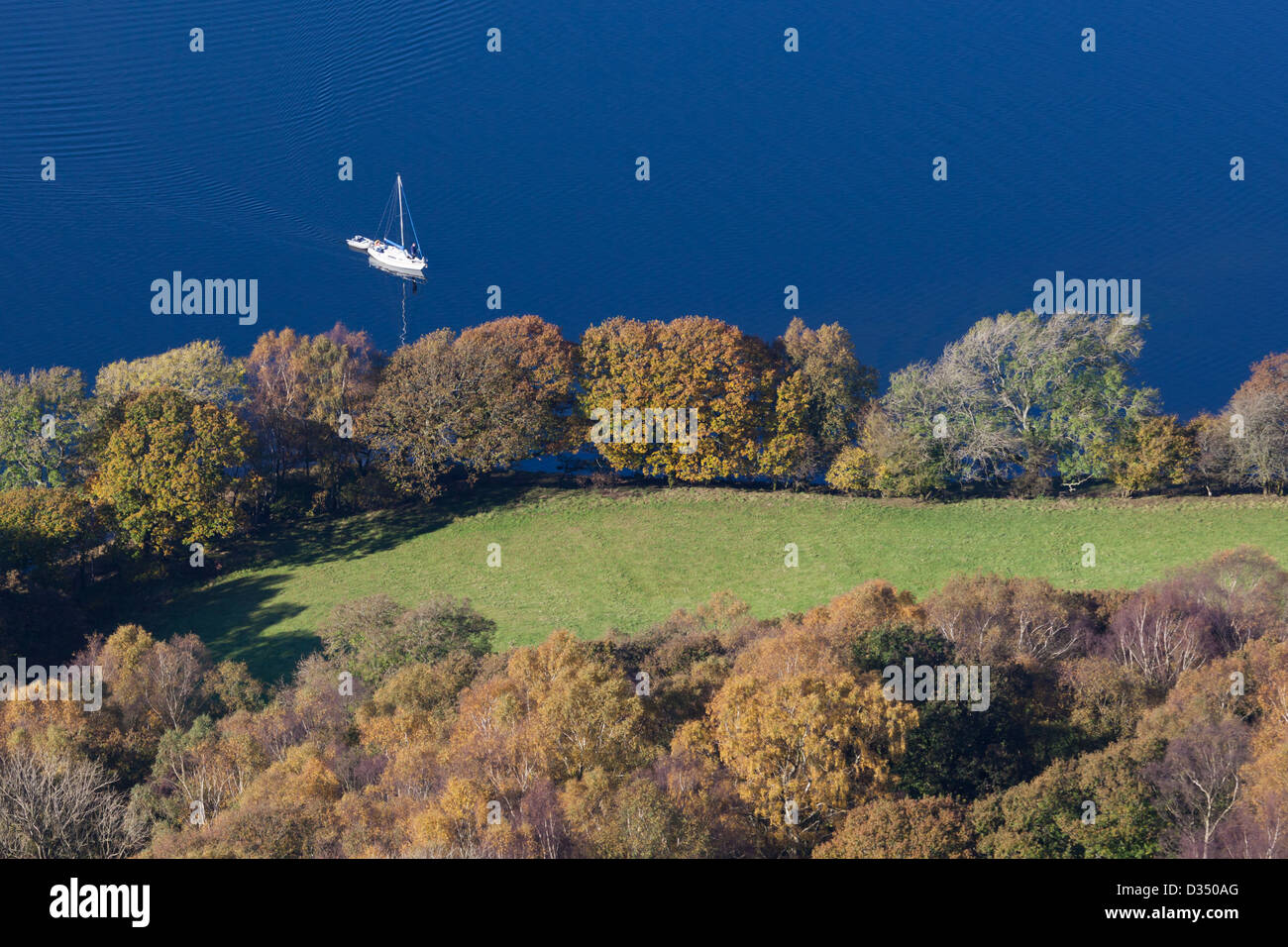 Boot auf einem noch Coniston Water im Herbst (Herbst). Entnommen aus einem hohen Aussichtspunkt in Grizedale Wald im Osten des Sees. Stockfoto