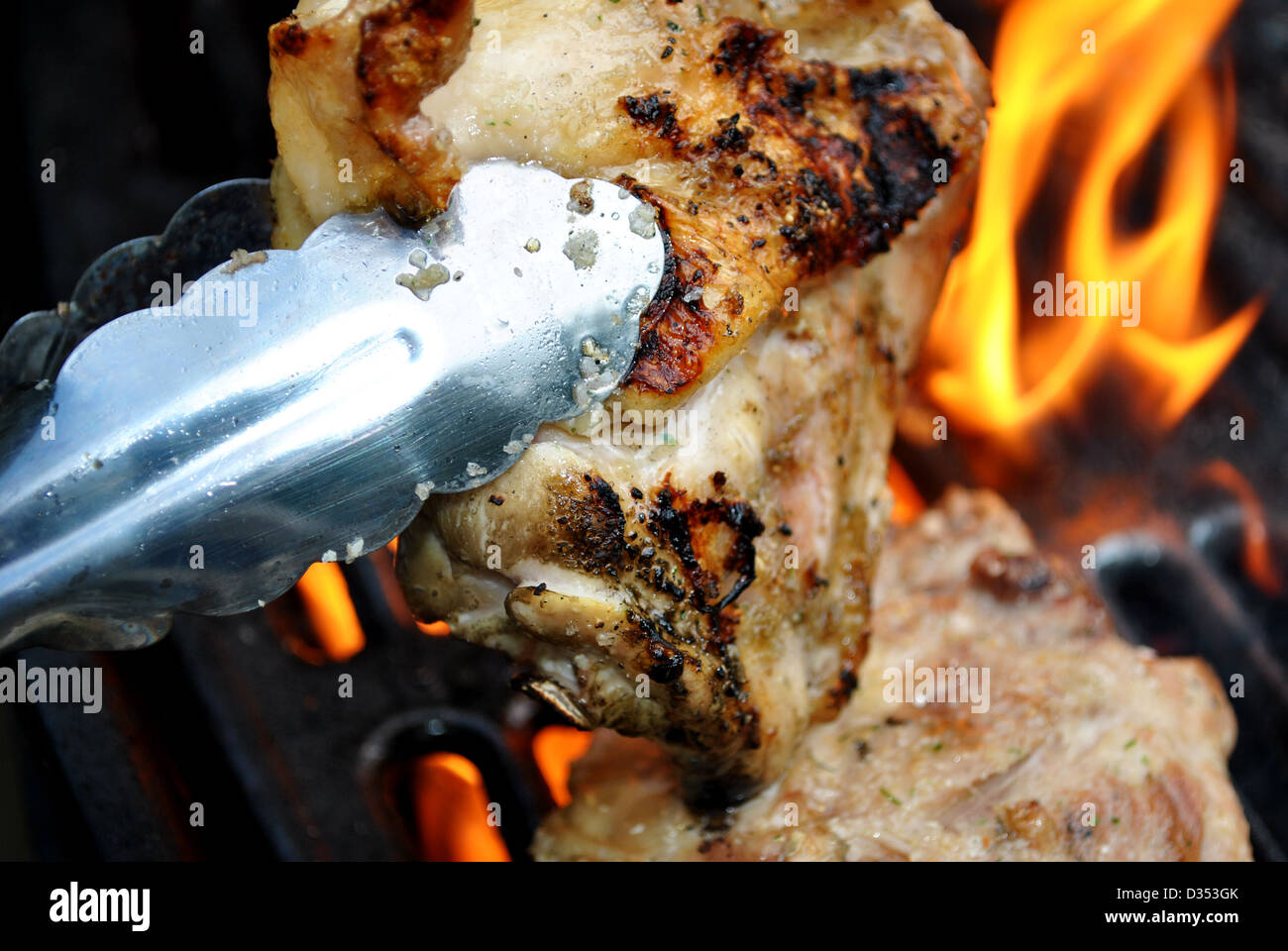 Flammende Hähnchenschenkel auf dem Grill Stockfoto