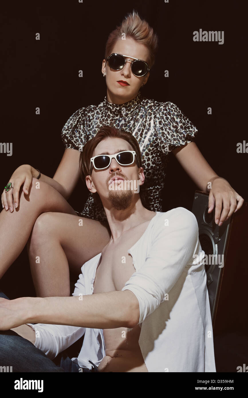 Studio-Porträt der jungen Männer und Frauen tragen eine stilvolle Sonnenbrille auf schwarzem Hintergrund Stockfoto