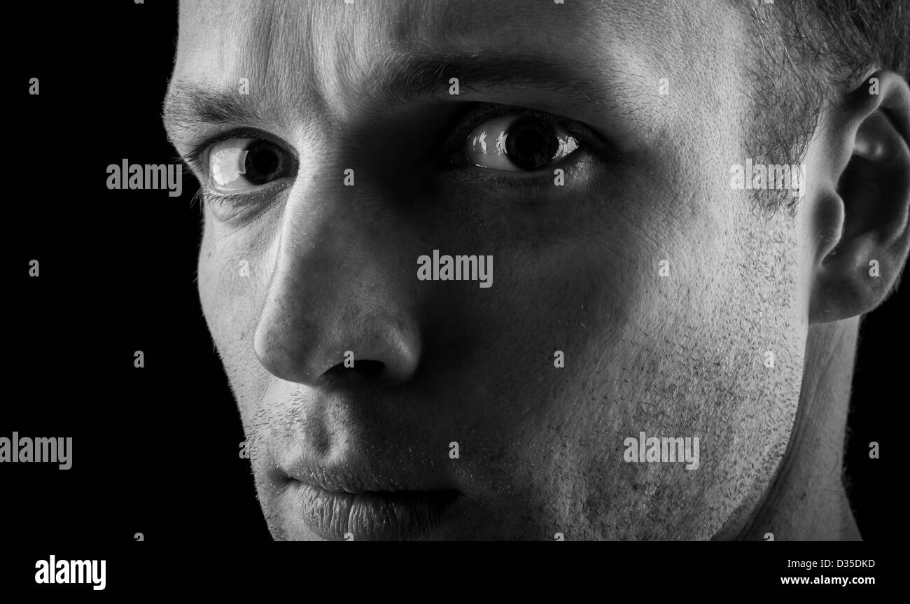 Kaukasische Jünglings Closeup monochrome Portrait auf schwarzem Hintergrund Stockfoto