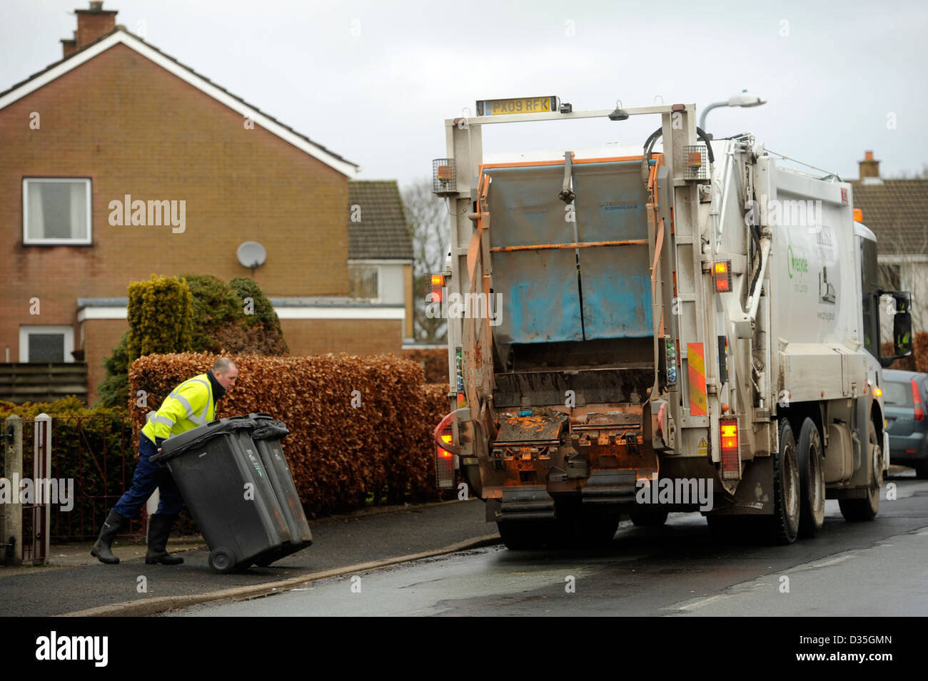 Müllabfuhr. Ein Mann bin mündet ein Abfall Verdichtung Truck Wheelie Lagerplätze von Müll, Müll, Müll Stockfoto