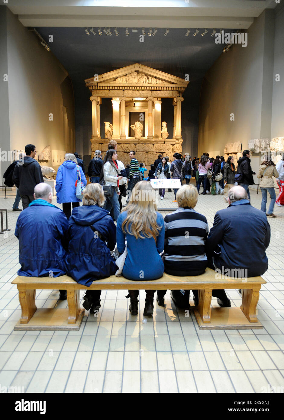 Fünf Leute sitzen auf einer Bank im British Museum, London Stockfoto