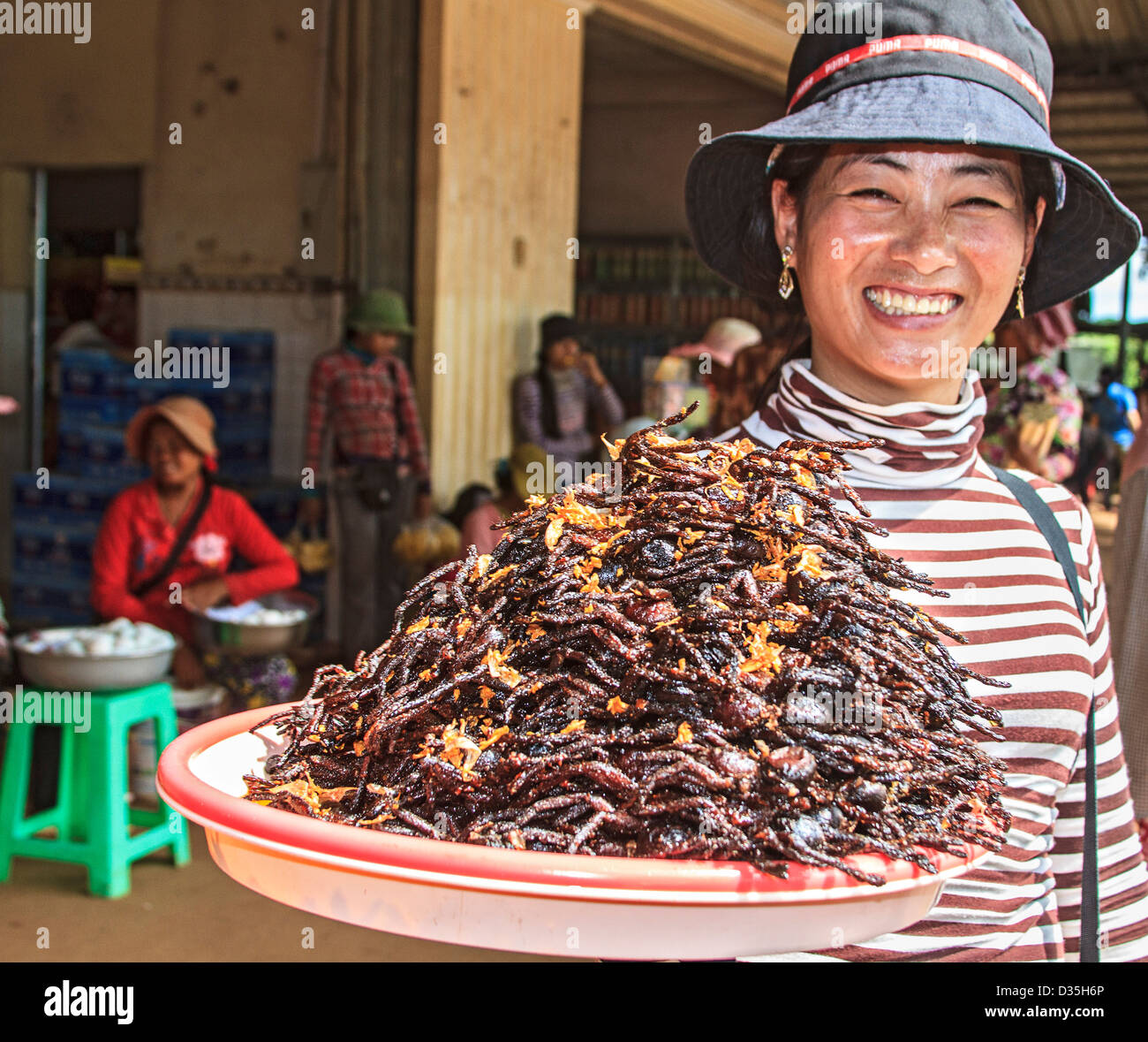 Frau mit einem Erdhaufen paniert und tiefe gebratenen Vogelspinnen zum Verkauf an Skuon, Kambodscha, bekannt als "Spiderville." Stockfoto