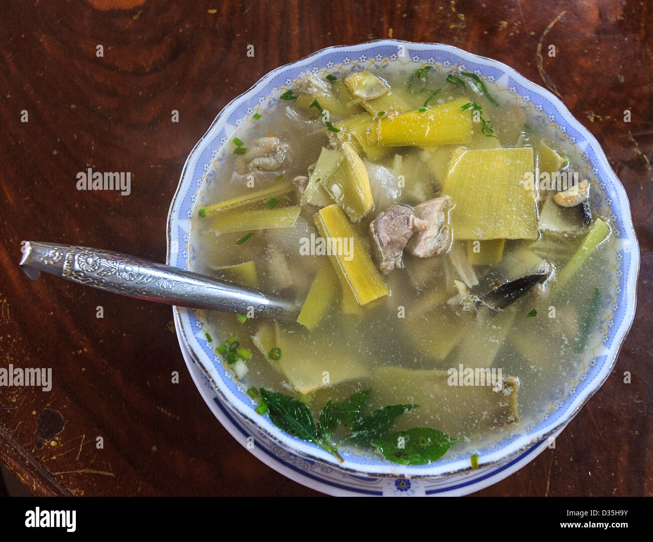 Saure Suppe, ein Khmer-Gericht, das eine Vielzahl von Fleisch haben kann. Hier hat die Suppe Huhn, Blätter und Blüten, Banane Kalk. Kambodscha. Stockfoto