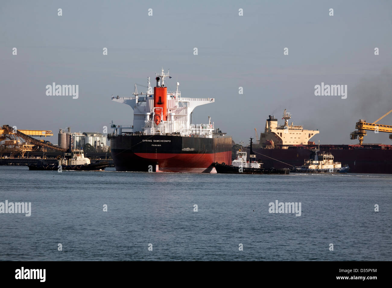 Panamax Dry Bulk Carrier von drei Hafen Schlepper an ihrem Liegeplatz an der Kooragang Kohle Loader Newcastle Australia unterstützt. Stockfoto