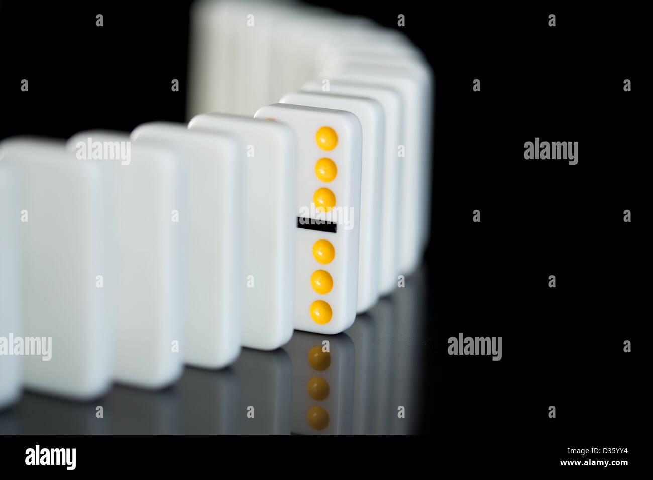 Eine gelbe Domino in einer Reihe von weißen Stockfoto
