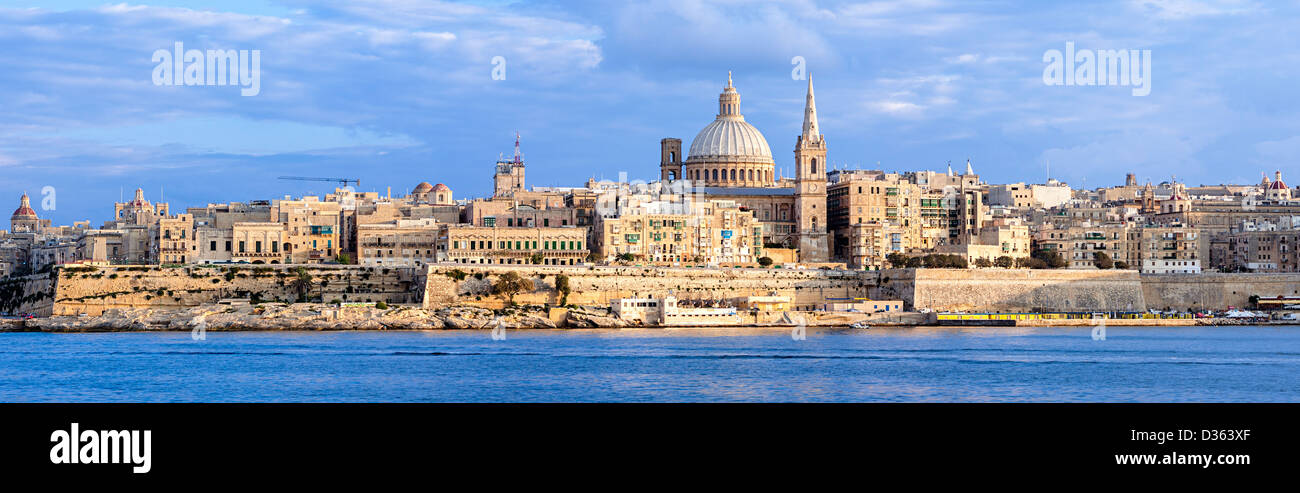 Die untergehende Sonne wirft seinen warmen Schein über die alte Stadt Valletta auf Malta. Stockfoto