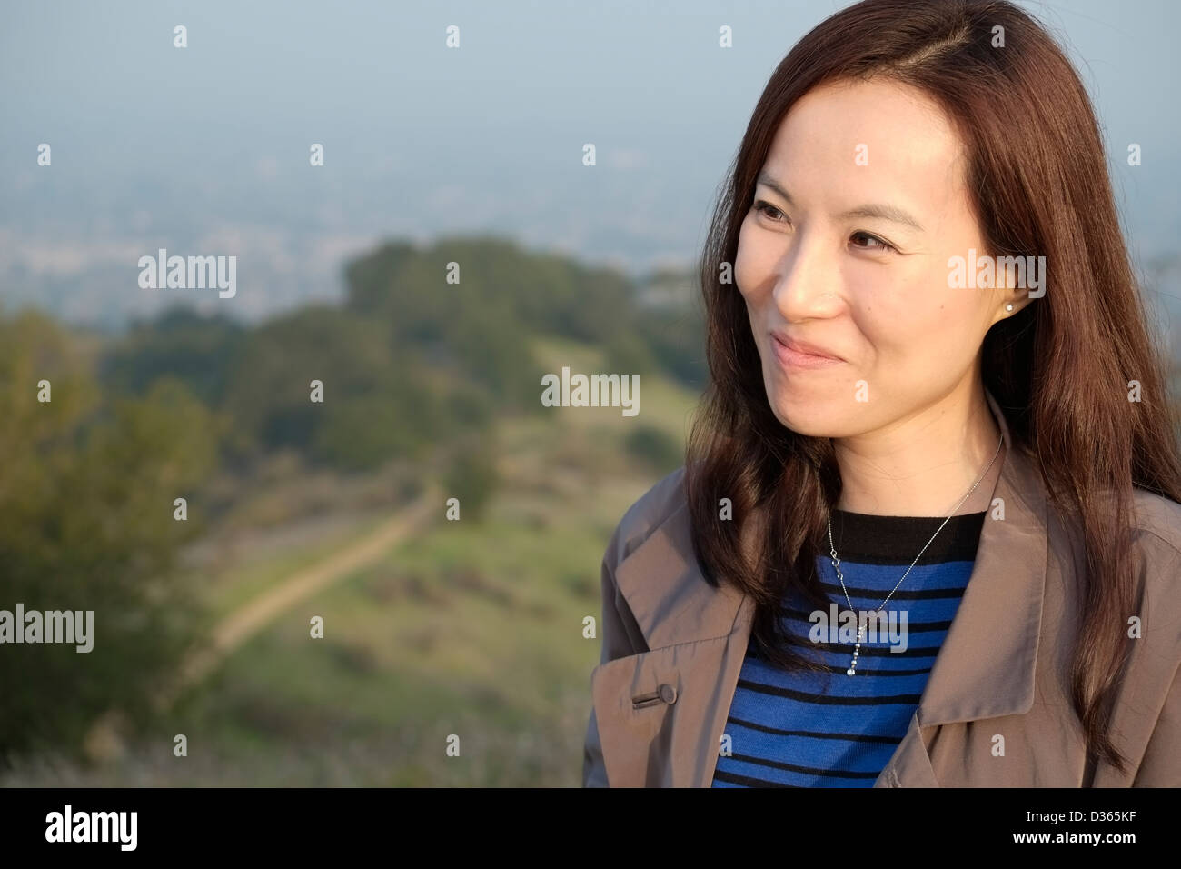 Stilvolle asiatische Frau lächelnd im Aussenbereich Stockfoto