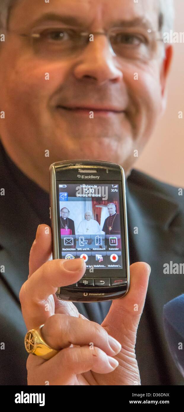 Diözesan-Administrator Auxillary Bischof Reinhard Hauke hält sein Handy mit einem Bild von ihm mit Papst Benedict XVI und Bischof Wanke in Erfurt, Deutschland, 11. Februar 2013. Er sprach über den Rücktritt von Papst Benedict XVI. Foto: Michael Reichel Stockfoto
