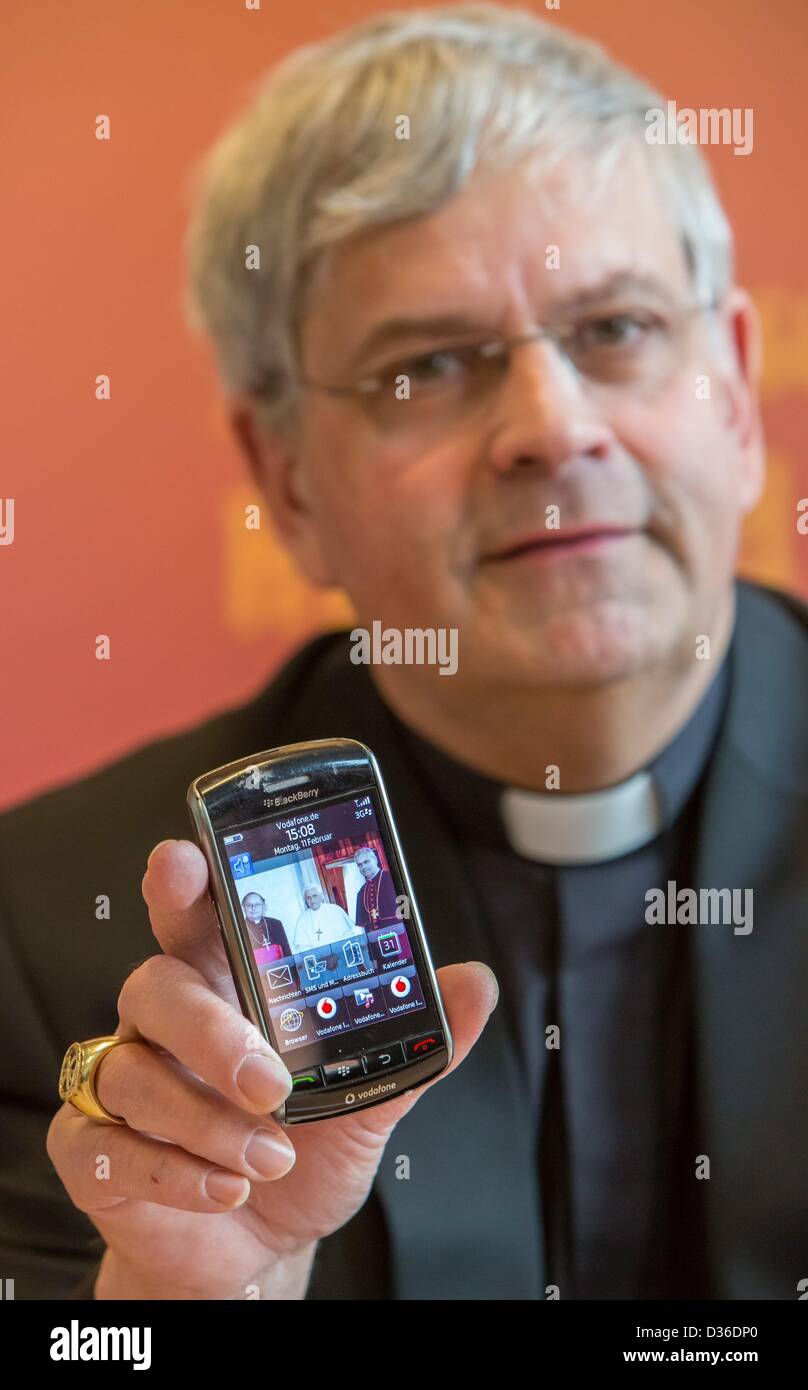 Diözesan-Administrator Auxillary Bischof Reinhard Hauke hält sein Handy mit einem Bild von ihm mit Papst Benedict XVI und Bischof Wanke in Erfurt, Deutschland, 11. Februar 2013. Er machte eine Aussage über den Rücktritt von Papst Benedict XVI. Foto: Michael Reichel Stockfoto