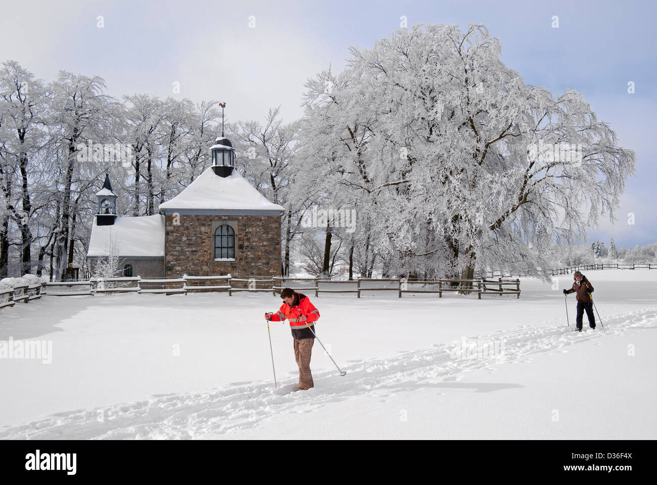 Langläufer, Bäume und Fischbach Kapelle im Schnee im Winter, Baraque Michel, hohe Venn / Hautes Fagnes, Ardennen, Belgien Stockfoto