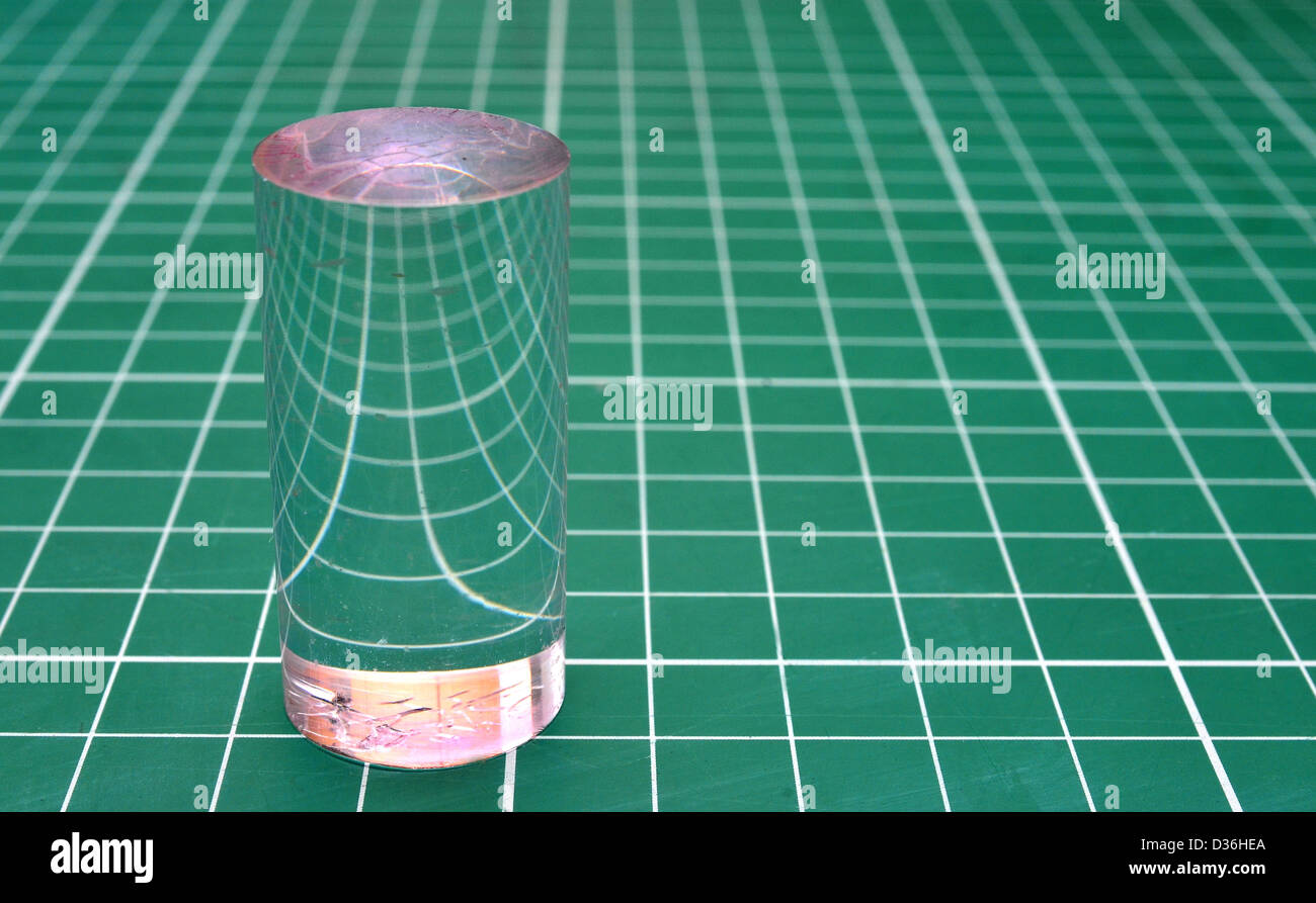 Plexiglas-Zylinder, die Brechung des Lichts auf einem quadratischen Raster Stockfoto