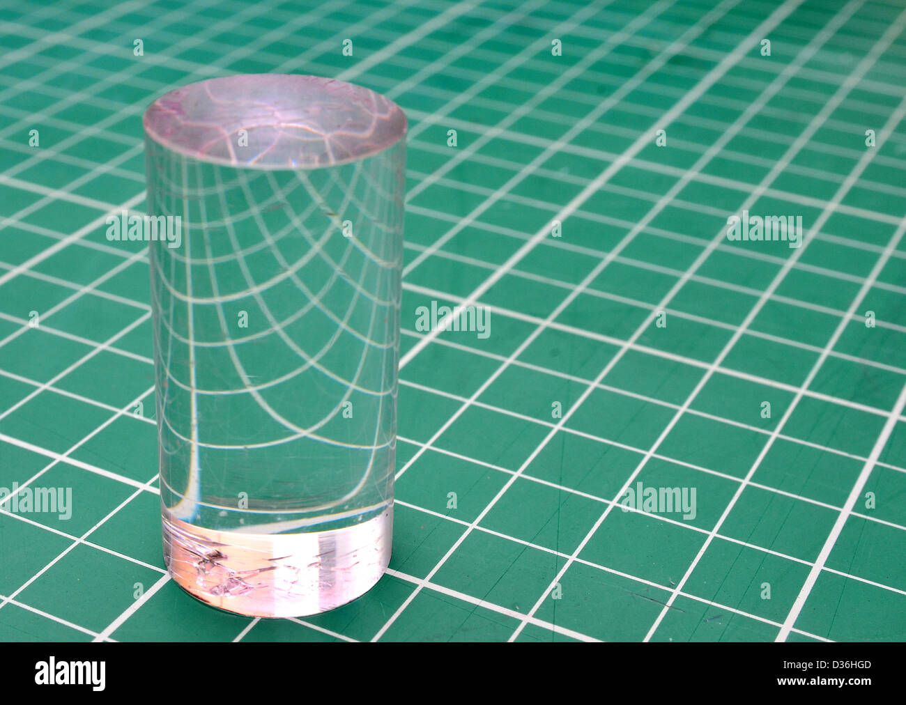 Plexiglas-Zylinder, die Brechung des Lichts auf einem quadratischen Raster Stockfoto