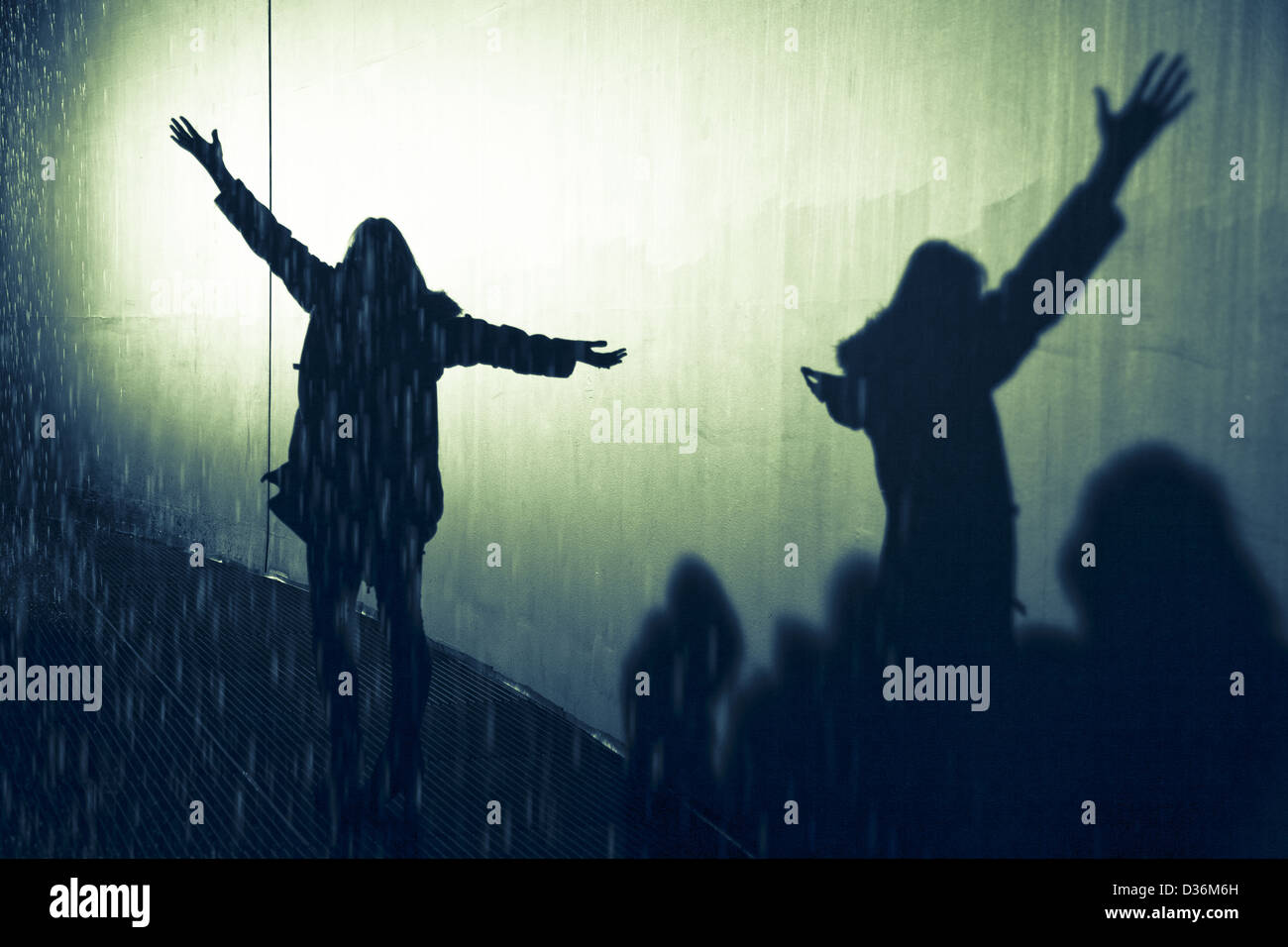 Schatten der Silhouette Frau im Regen mit Arme öffnen und ausgestreckt, den Regen zu genießen Stockfoto
