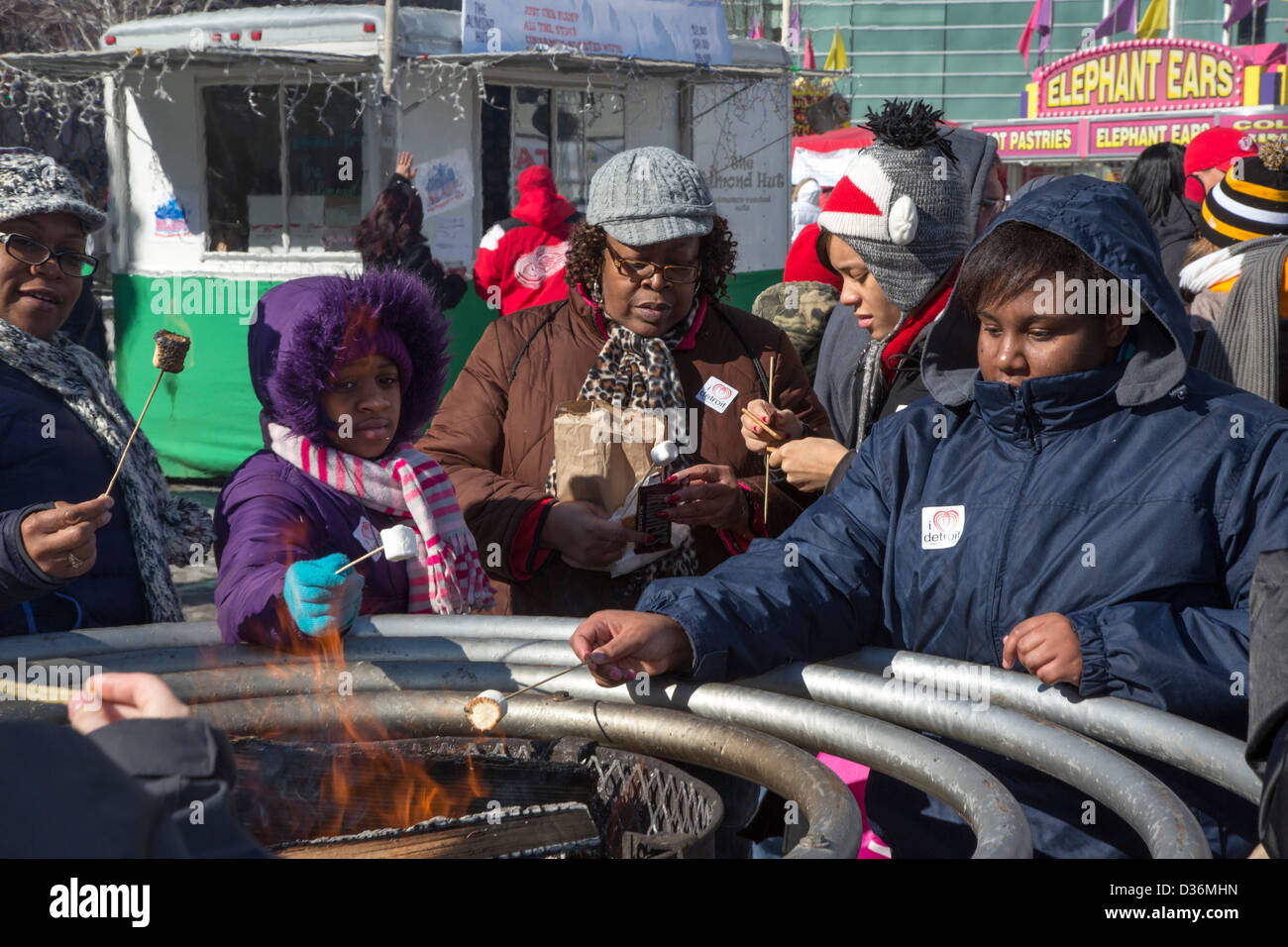 Frauen Rösten Marshmallows über dem Feuer im Campus Martius Park in Detroit Winter Blast Festival. Stockfoto