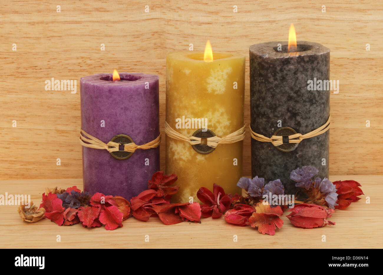 Drei brennende Feng Shui Kerzen und Potpourri aus Holz im Hintergrund Stockfoto