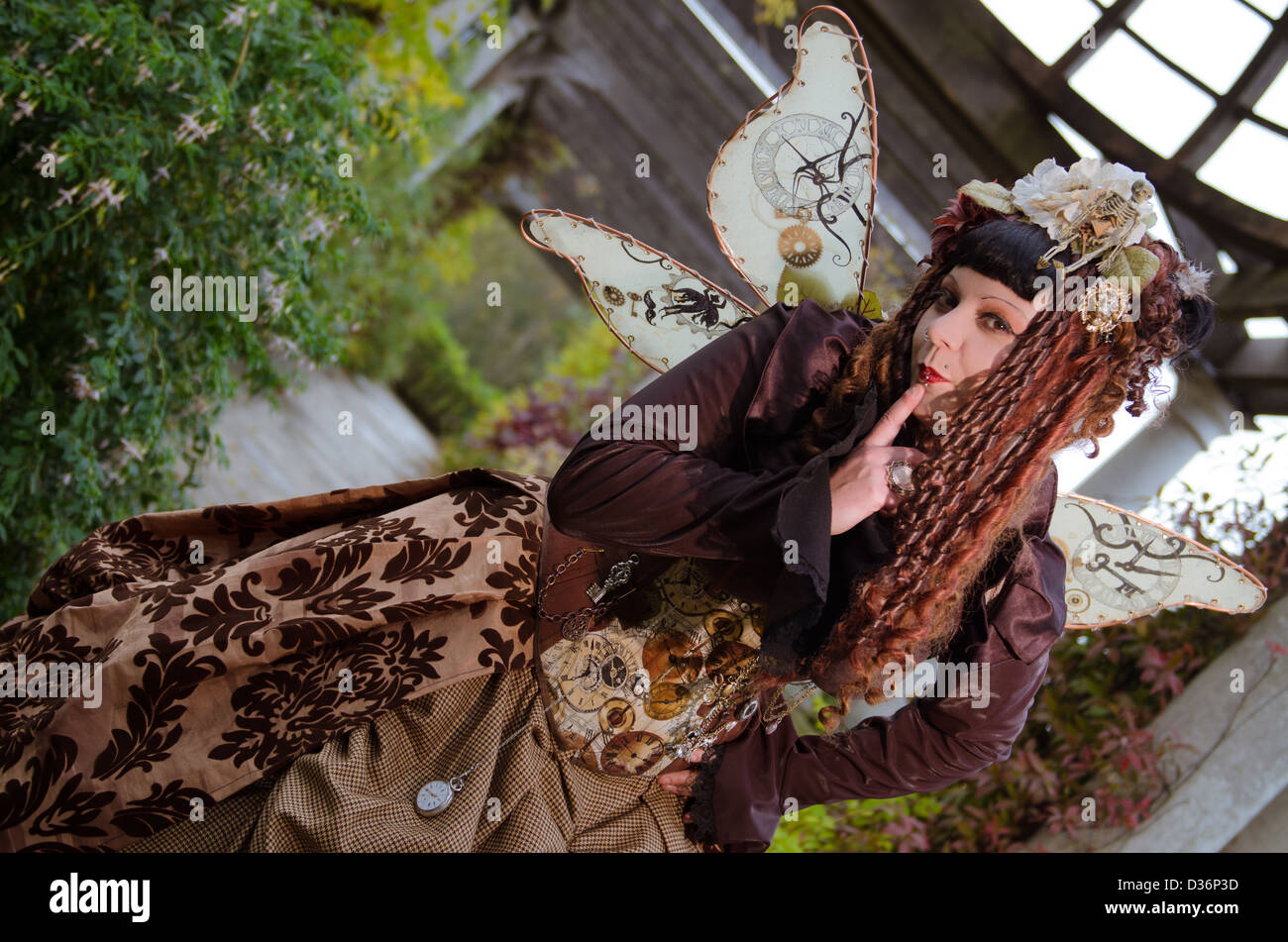 Kaukasische Frau trägt braune Steampunk Kleidung und Fee Flügel Stockfoto