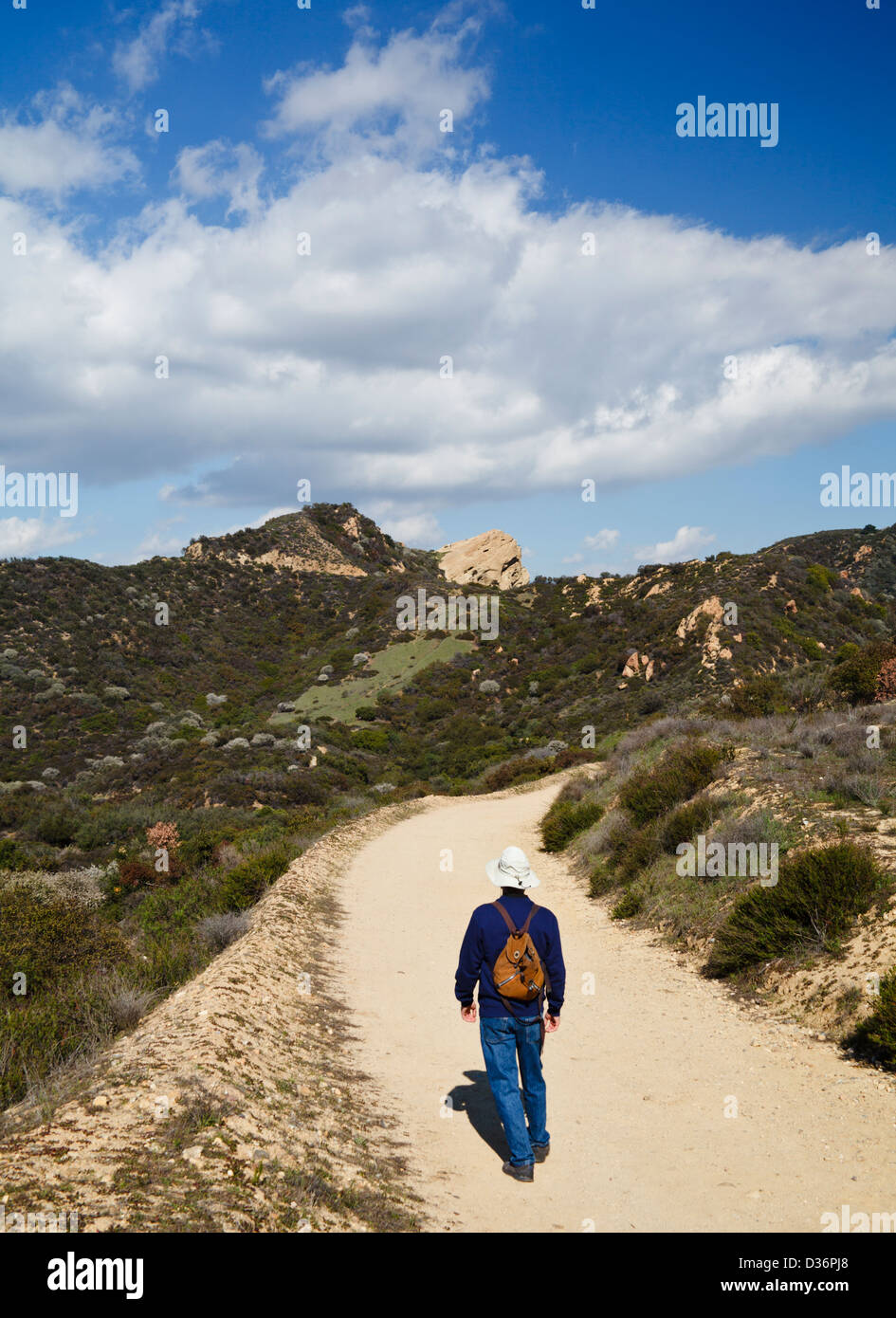 Wanderer geht auf Feuer Road in Richtung Eagle Rock, gesehen in Ferne, im Topanga State Park in Topanga, Kalifornien Stockfoto