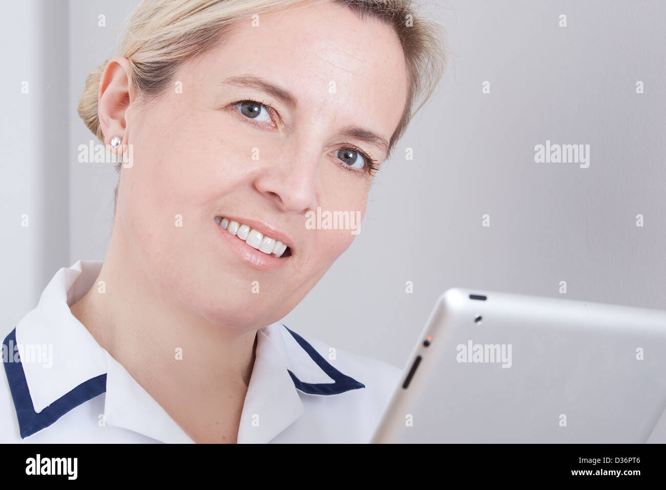 Medizinische Arbeitnehmerin Blick in die Kamera hält eine digitale-Tablette. Stockfoto