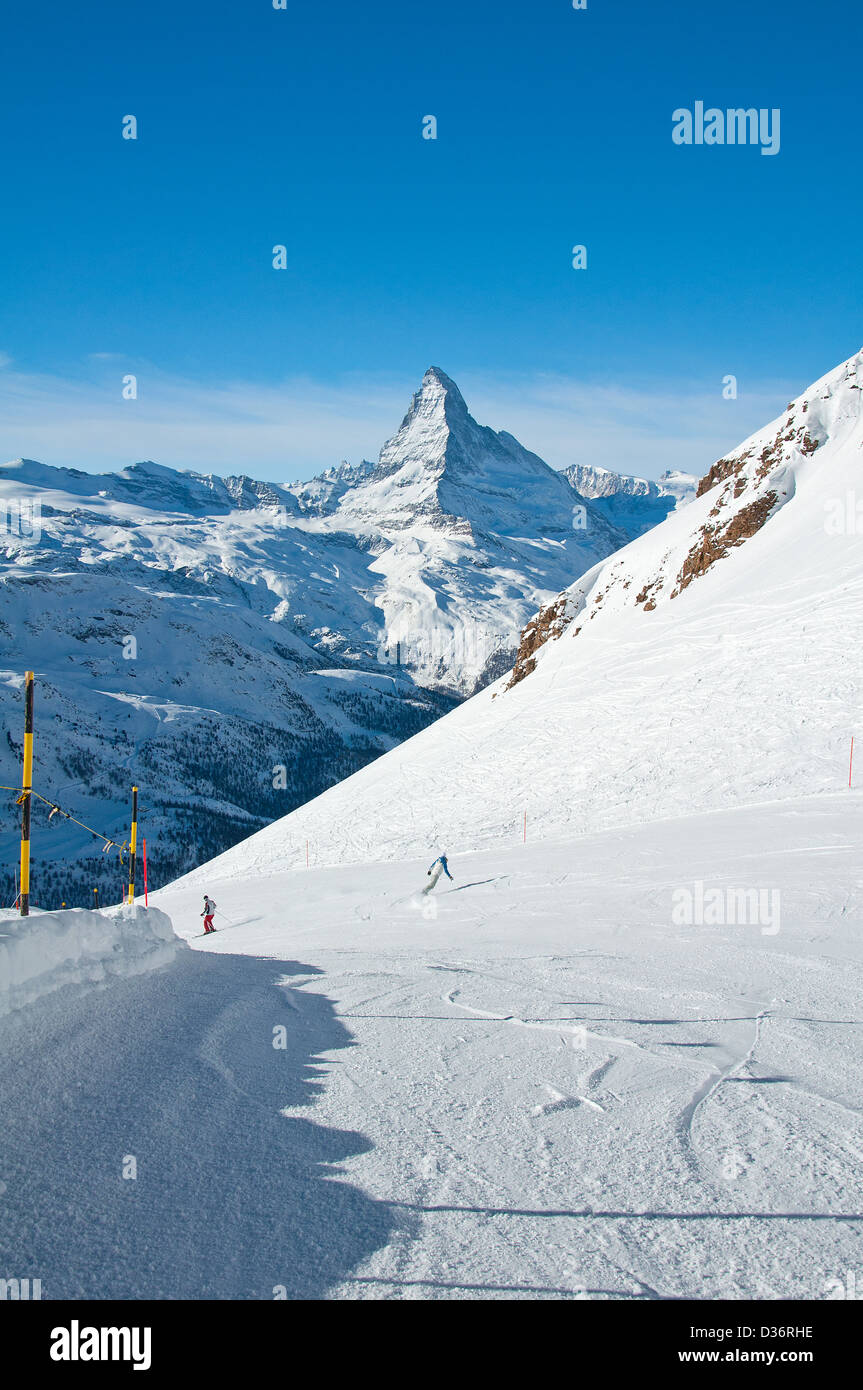 Skifahrer und Snowboarder auf der Piste mit Matterhorn im Hintergrund Stockfoto
