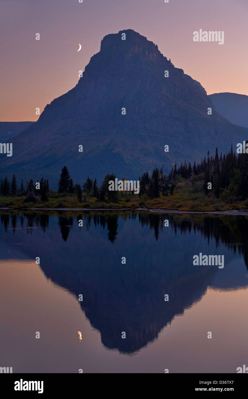 Berg- und Mond spiegeln sich in einem Teich im Glacier National Park, Montana. USA Stockfoto