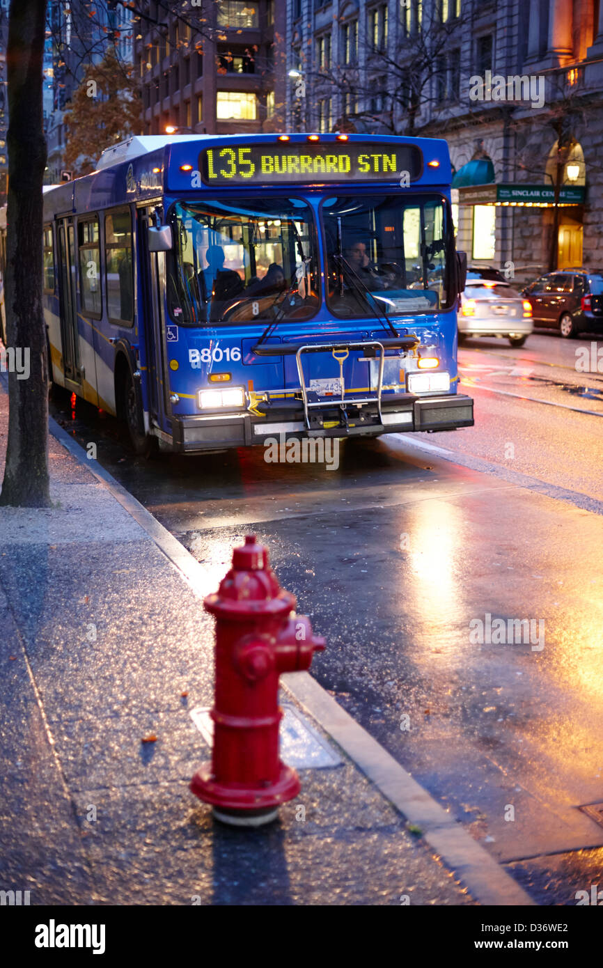 Vancouver City-Bus Haltestelle auf nassen Straße in frühen Abend im Stadtzentrums BC Kanada Stockfoto