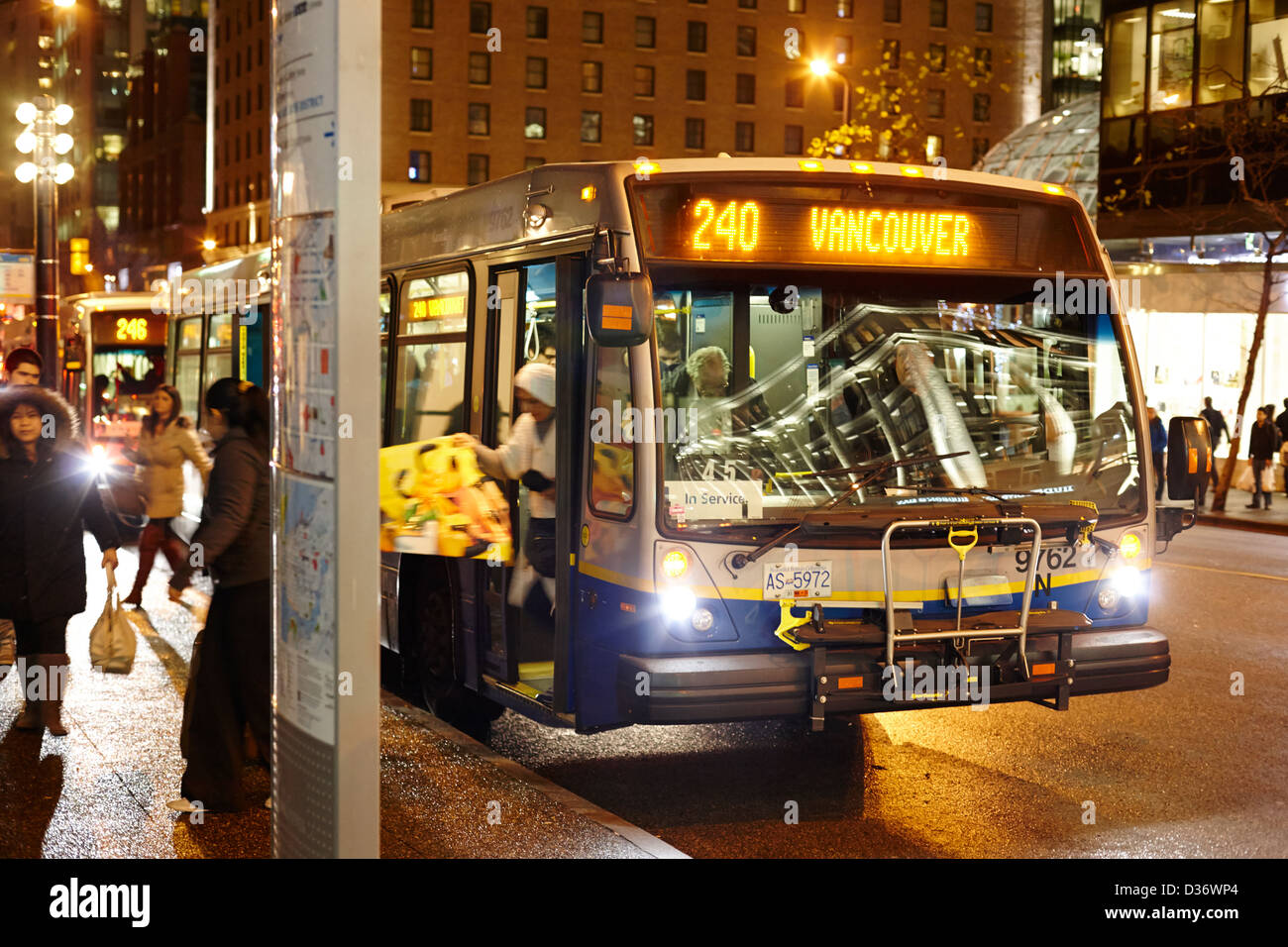 Passagiere aus Vancouver Stadtbus am stoppen auf nasser Straße frühen Abend im Stadtzentrums BC Kanada Stockfoto