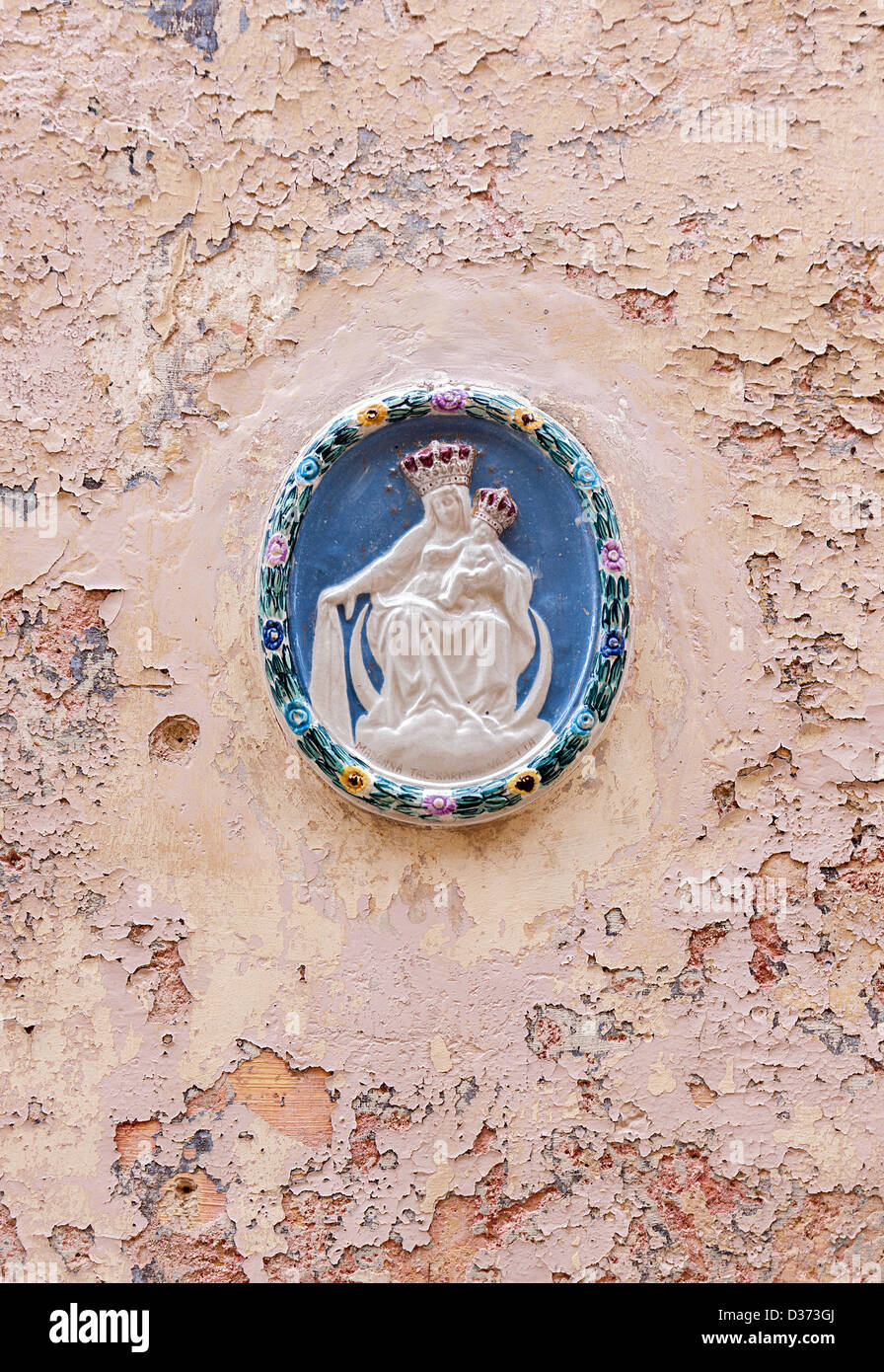 Schöne Tür Plakette mit dem Relief der Madonna mit Kind auf einem abblättern, bemalten Wand. Aufnahme in ummauerten Stadt Mdina, Malta Stockfoto