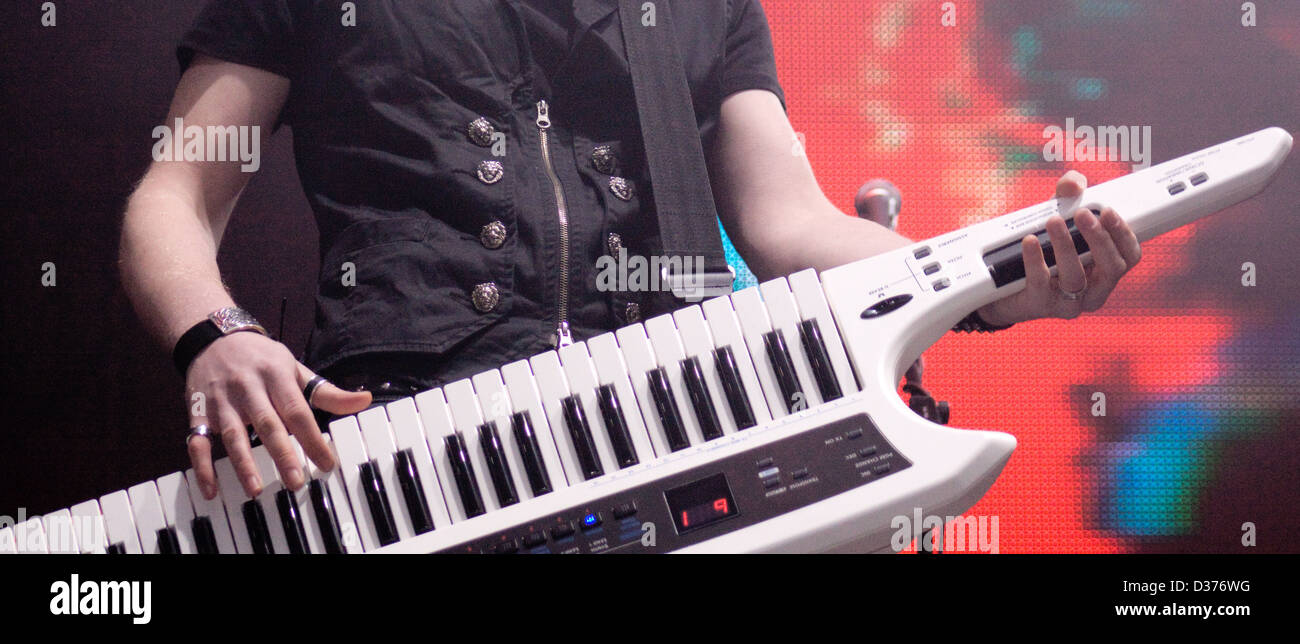 Man spielt auf einem Synthesizer auf einem dunklen Hintergrund Stockfoto