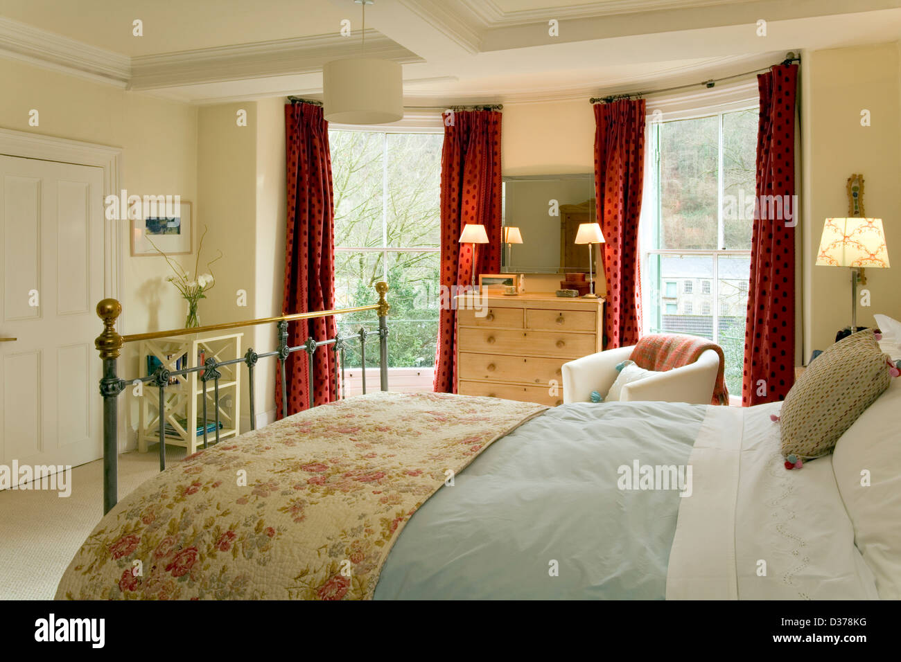Ein traditionell eingerichtetes Schlafzimmer mit zwei großen Fenstern. Stockfoto