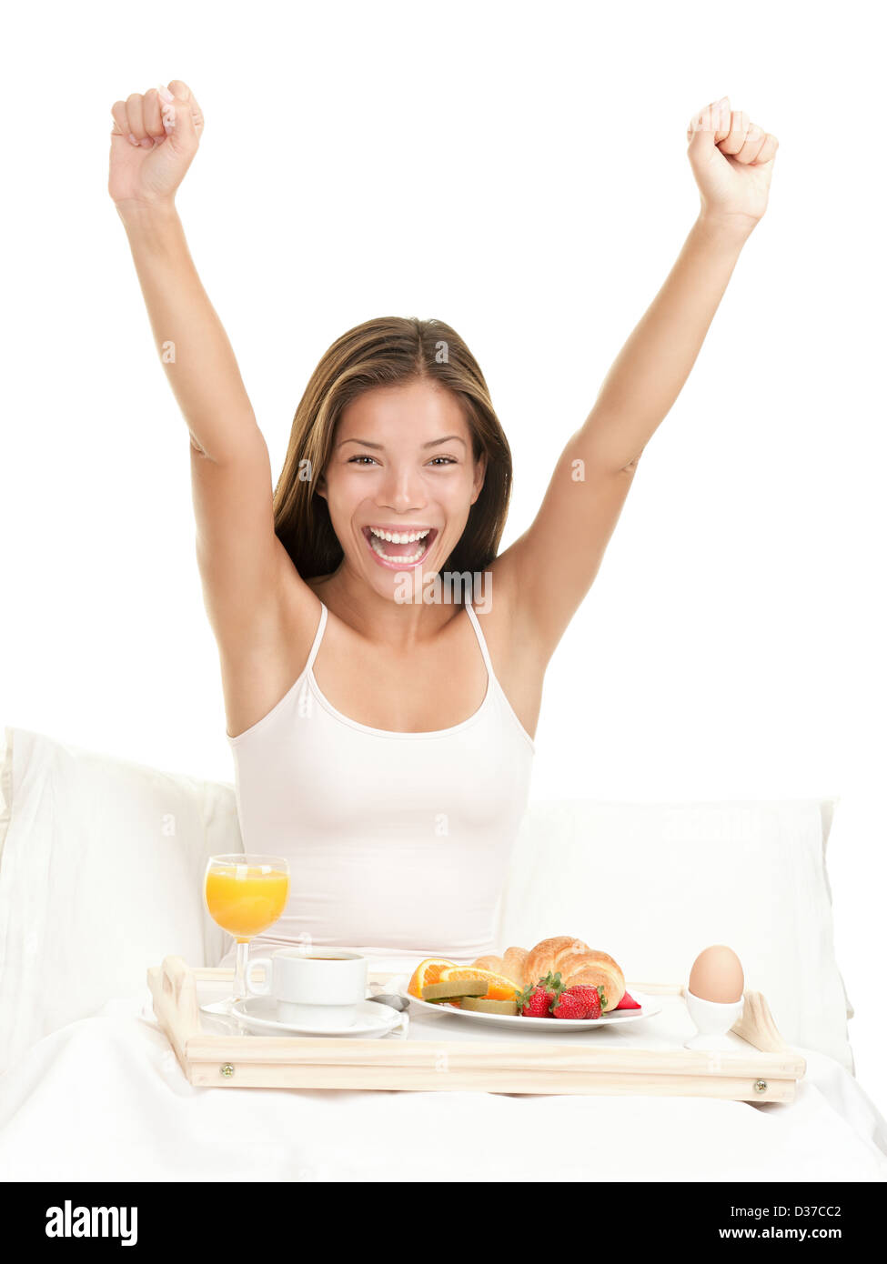 Porträt der schönen Morgen multikulturelle Asian kaukasischen Frau mit Frühstück Strecken Arme im Bett auf weißem Hintergrund Stockfoto