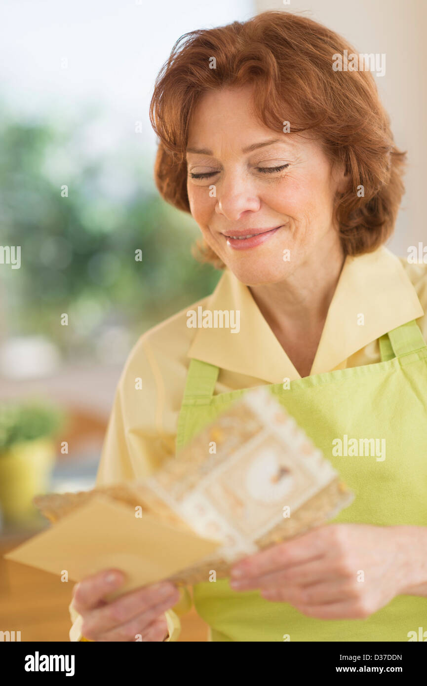 USA, New Jersey, Jersey City, Senior Frau liest Grußkarte Stockfoto