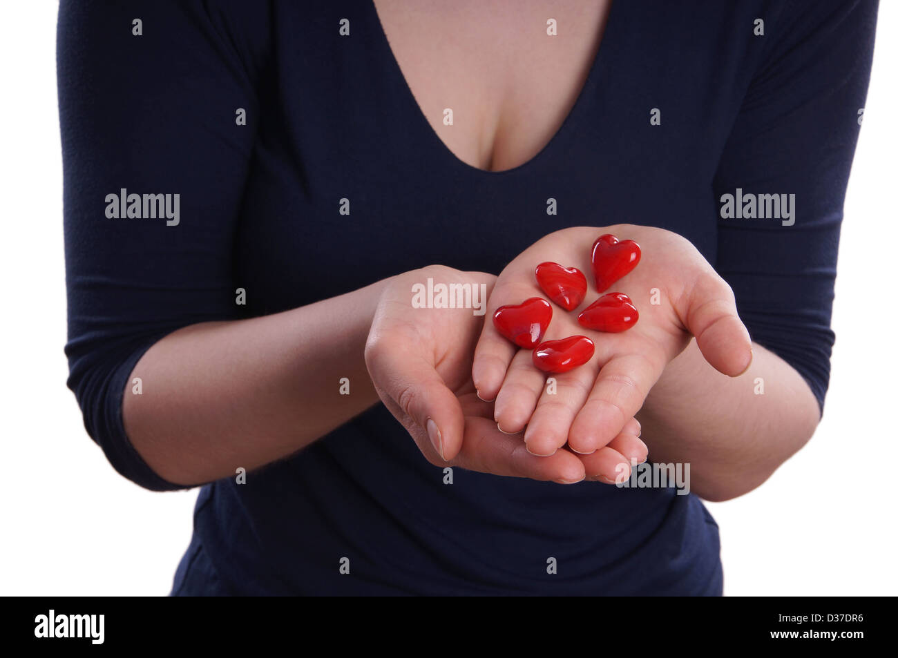 Frau präsentiert rote Keramik Herzen in ihren Händen Stockfoto