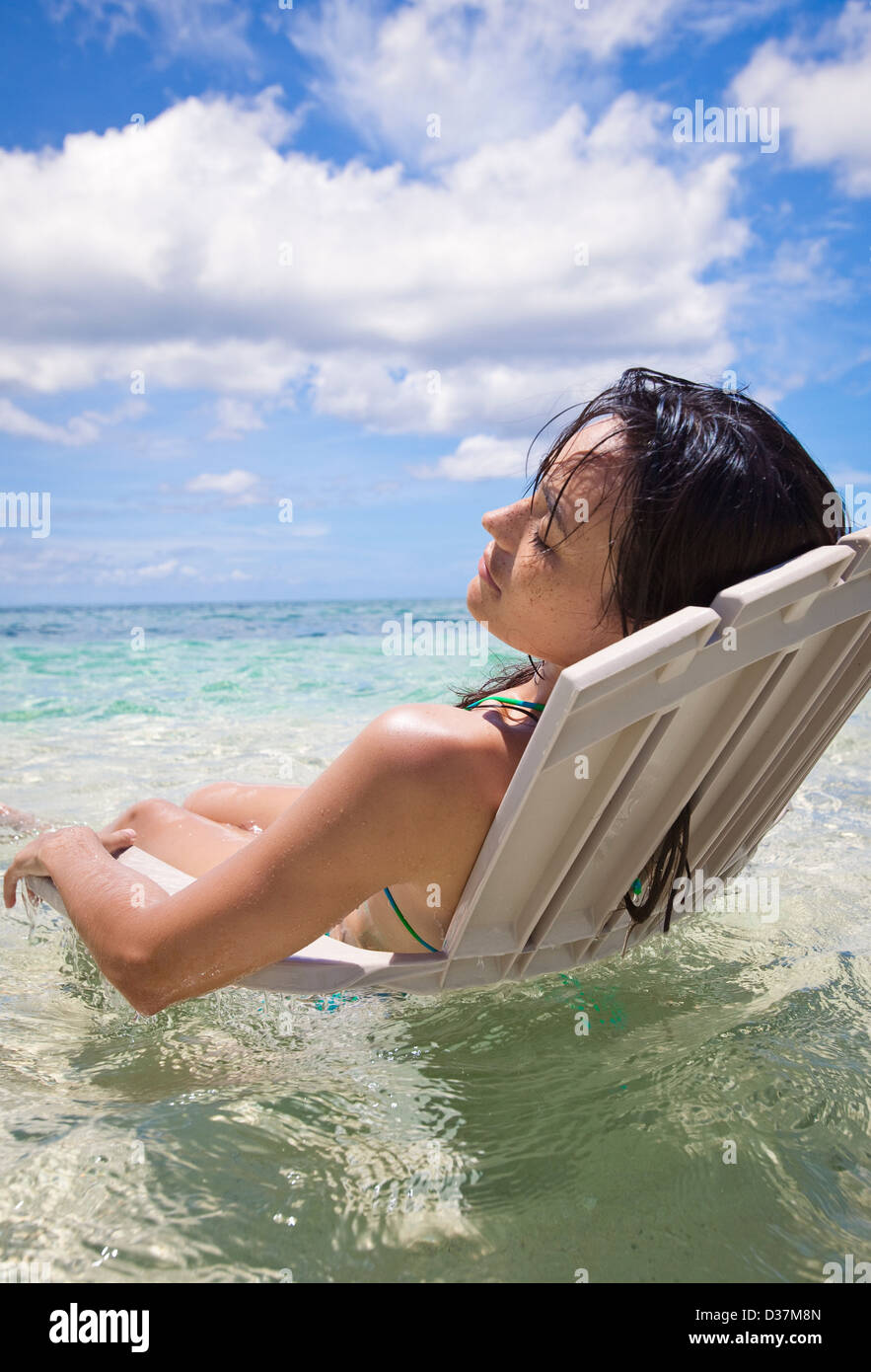 Frau im Liegestuhl im tropischen Wasser Stockfoto