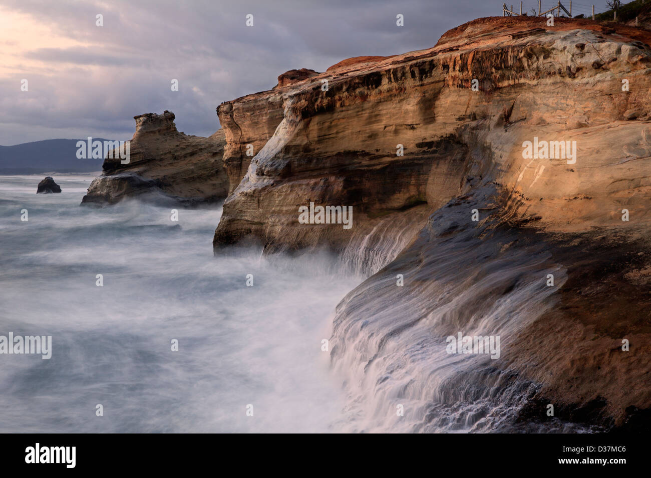 OR01026-00... OREGON - Surf schlagen die Sandsteinfelsen im Cape Kiwanda State Park. Stockfoto