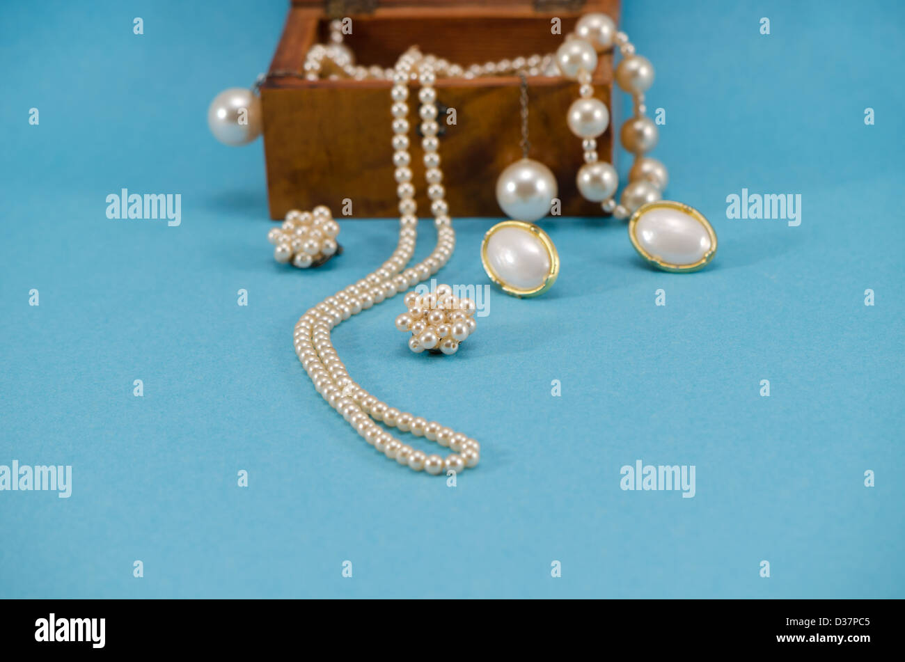 Perlenschmuck Perlen Halskette Ohrring in Retro-Holzkiste auf blauem Hintergrund. Stockfoto
