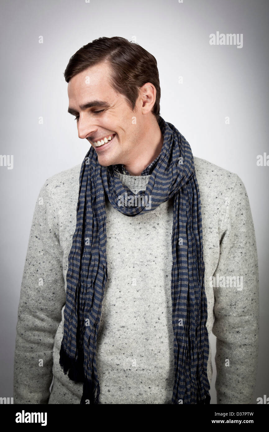 Lächelnder Mann trägt Schal im Innenbereich Stockfoto