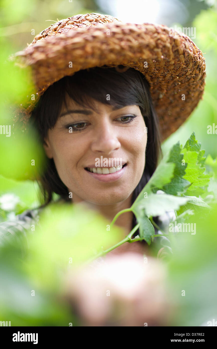 Lächelnde Frau in hohen Pflanzen stehen Stockfoto
